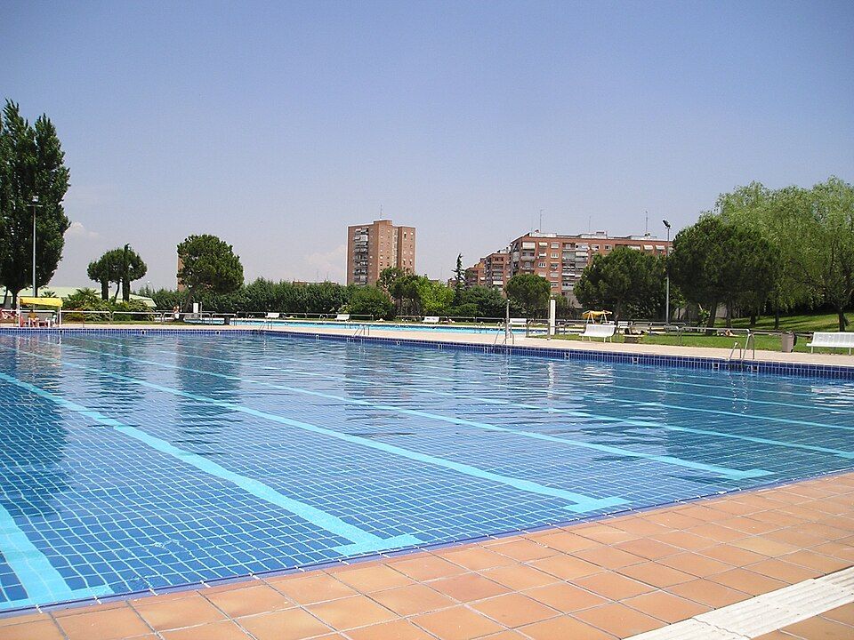Piscina municipal de verano de Hortaleza, con edificios del barrio al fondo