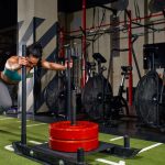 Deportista empujando un trineo en el gimnasio, una de las estaciones de HYROX