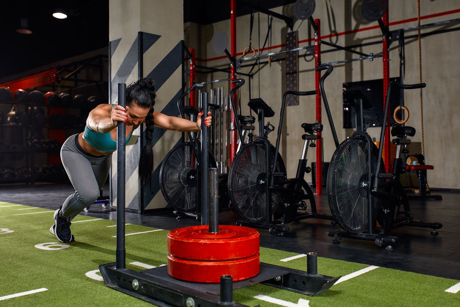 Deportista empujando un trineo en el gimnasio, una de las estaciones de HYROX