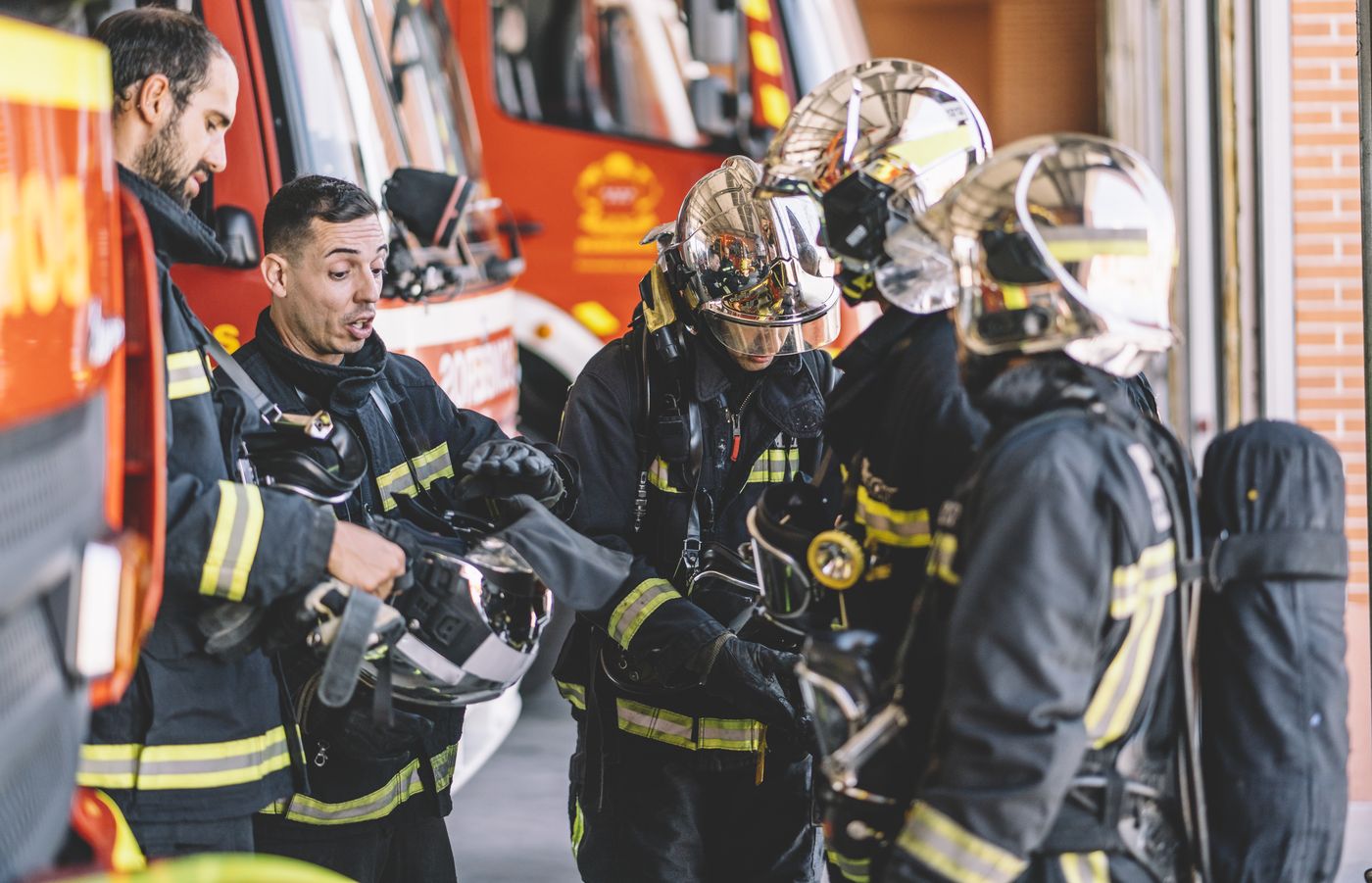 Bomberos con el equipo de protección junto al camión